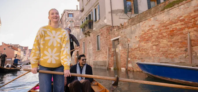A young woman rides on a gondola on a Contiki trip